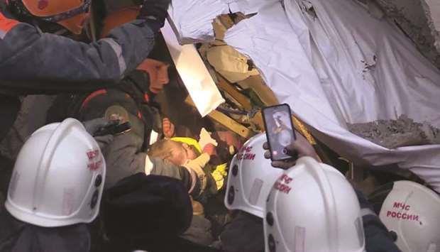 Infant rescued from collapsed building This handout picture released by the Russian emergencies ministry shows rescuers moving the baby from the rubble of the residential building in Magnit